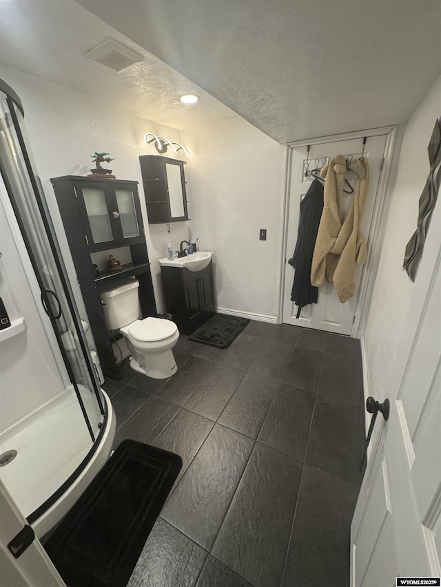 117 Sandstone Dr, Evanston, WY 82930 - bathroom featuring a stall shower, vanity, toilet, and tile patterned floors
