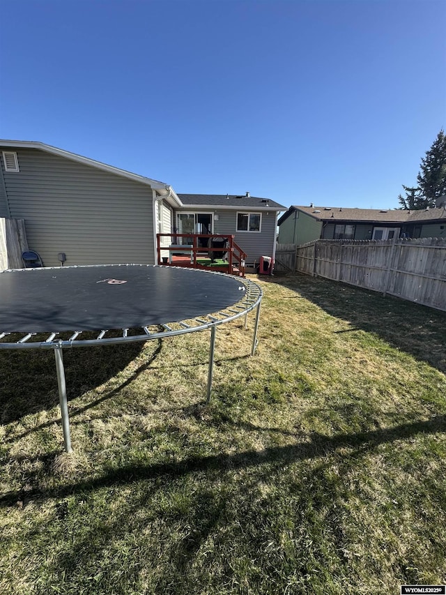 117 Sandstone Dr, Evanston, WY 82930 - view of yard with a fenced backyard, a deck, and a trampoline