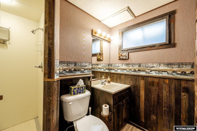 bathroom with toilet, vanity, and wainscoting