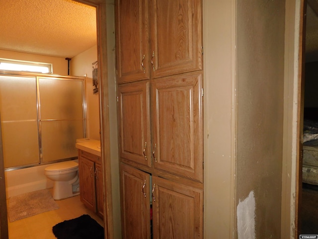 479 Hoskins Ln, Rock Springs, WY 82901 - bathroom with toilet, combined bath / shower with glass door, and a textured ceiling