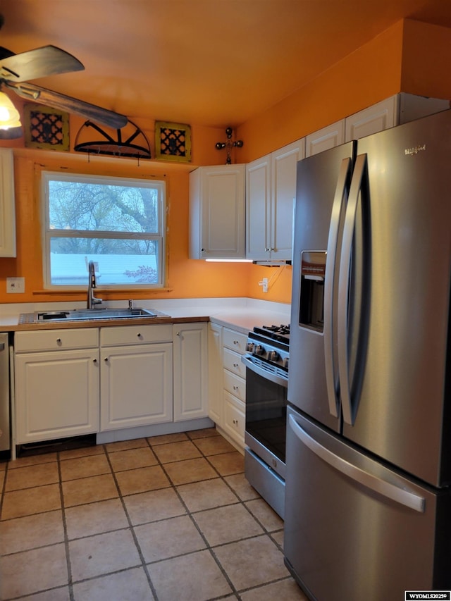1001 Country Club Rd, Casper, WY 82609 - kitchen with stainless steel appliances, a sink, white cabinets, and light tile patterned floors