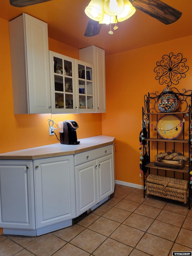 1001 Country Club Rd, Casper, WY 82609 - kitchen with light tile patterned flooring, white cabinets, light countertops, glass insert cabinets, and baseboards