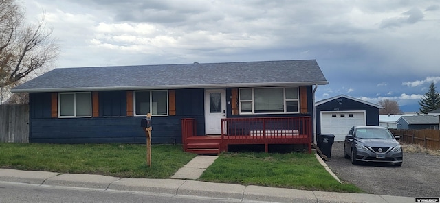 ranch-style house featuring fence, a shingled roof, an outdoor structure, a porch, and a detached garage
