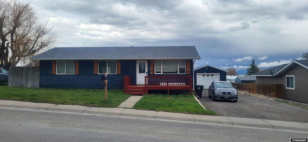 view of front of home with driveway, fence, a garage, a shingled roof, and a porch