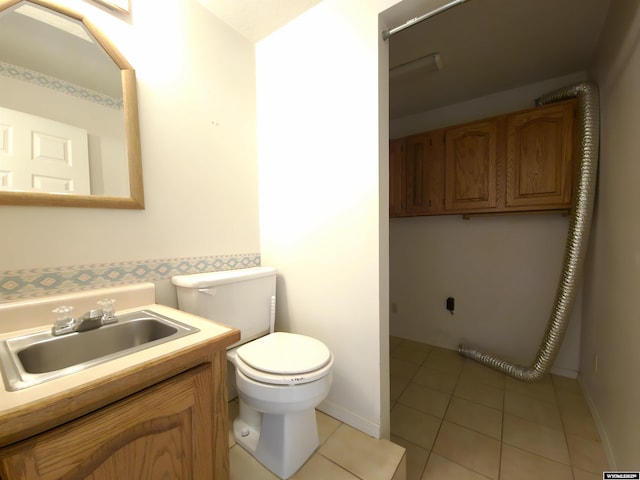 bathroom featuring vanity, toilet, baseboards, and tile patterned floors
