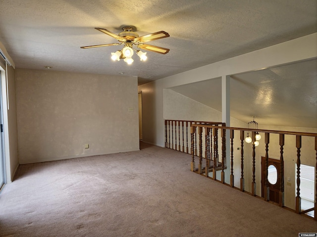 carpeted spare room with a textured ceiling and a ceiling fan