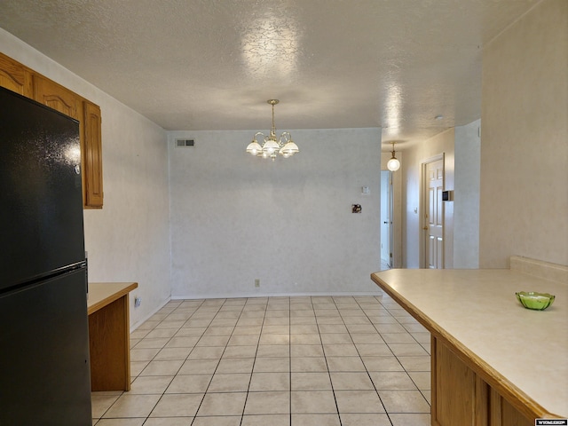 dining area with an inviting chandelier, a textured ceiling, and visible vents
