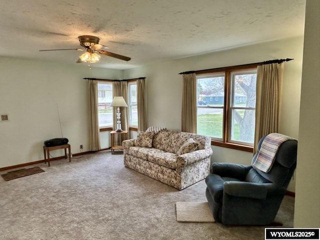 carpeted living room with a ceiling fan