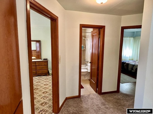 corridor featuring carpet floors and baseboards