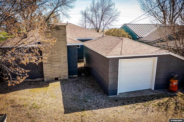 view of property exterior featuring a shingled roof, crawl space, and an outbuilding