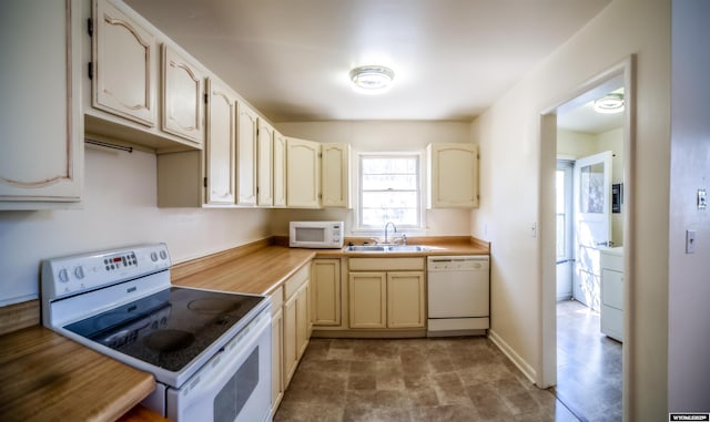 kitchen with white appliances, a sink, washer / clothes dryer, and light countertops