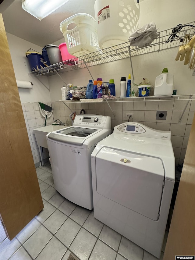 191 Lester Dr, Rock Springs, WY 82901 - laundry area featuring tile walls, light tile patterned flooring, washing machine and dryer, and a wainscoted wall