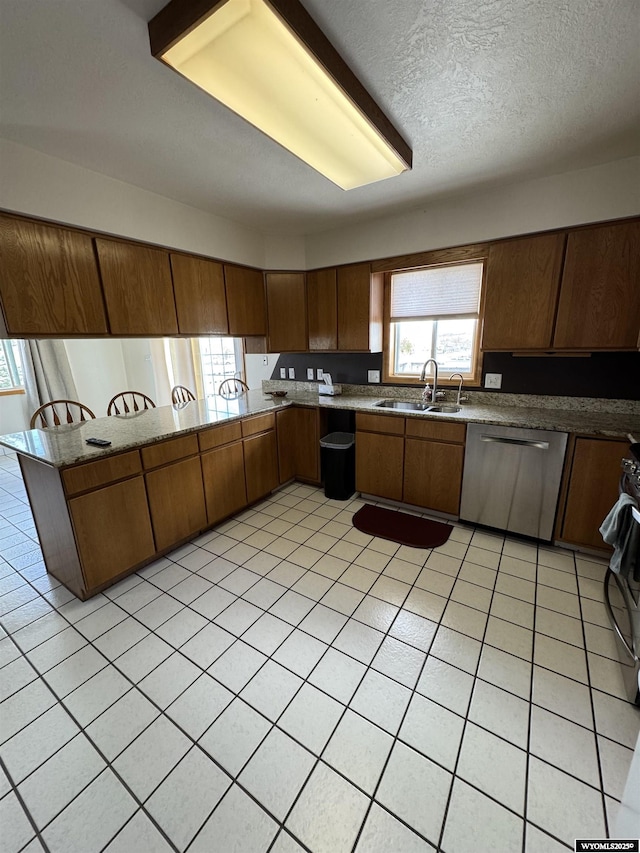 191 Lester Dr, Rock Springs, WY 82901 - kitchen featuring a sink, stainless steel dishwasher, a peninsula, range, and brown cabinetry