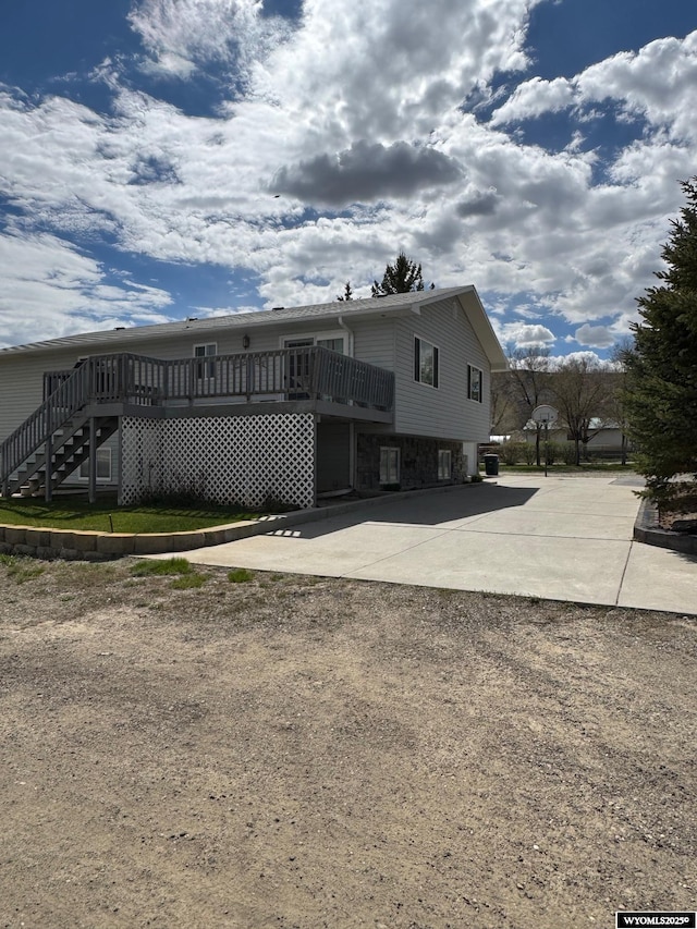 191 Lester Dr, Rock Springs, WY 82901 - view of front of property featuring stone siding, a deck, stairway, and driveway