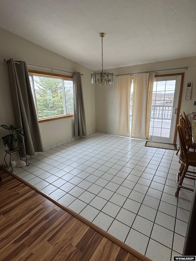191 Lester Dr, Rock Springs, WY 82901 - unfurnished dining area featuring a chandelier, light tile patterned flooring, and lofted ceiling
