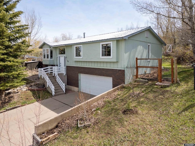 147 Apache Dr, Evanston, WY 82930 - view of front of property featuring an attached garage, driveway, metal roof, and brick siding