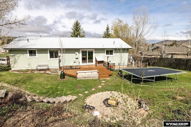 147 Apache Dr, Evanston, WY 82930 - rear view of property with a trampoline, a wooden deck, and metal roof