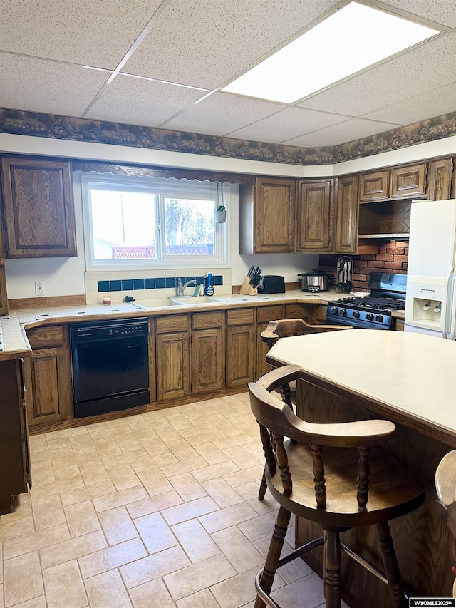 618 Emerald St, Kemmerer, WY 83101 - kitchen featuring black dishwasher, stainless steel range with gas stovetop, white refrigerator with ice dispenser, light countertops, and a sink