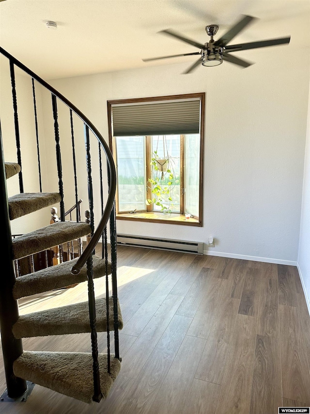618 Emerald St, Kemmerer, WY 83101 - staircase with baseboard heating, ceiling fan, wood finished floors, and baseboards
