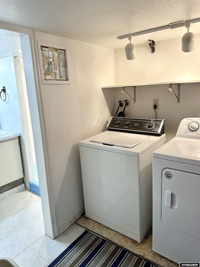 laundry area with separate washer and dryer, a textured ceiling, and rail lighting