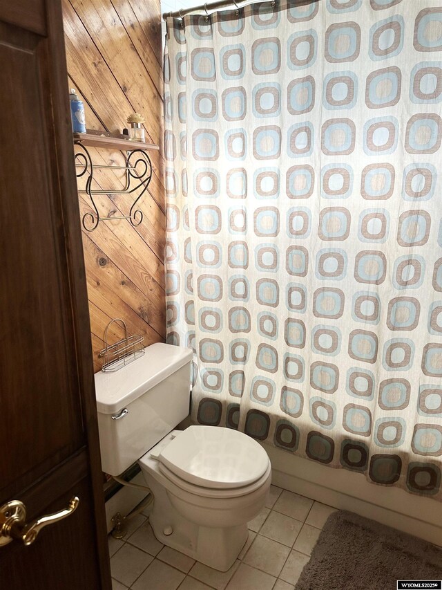618 Emerald St, Kemmerer, WY 83101 - full bathroom with wood walls, tile patterned flooring, toilet, and shower / bath combo with shower curtain