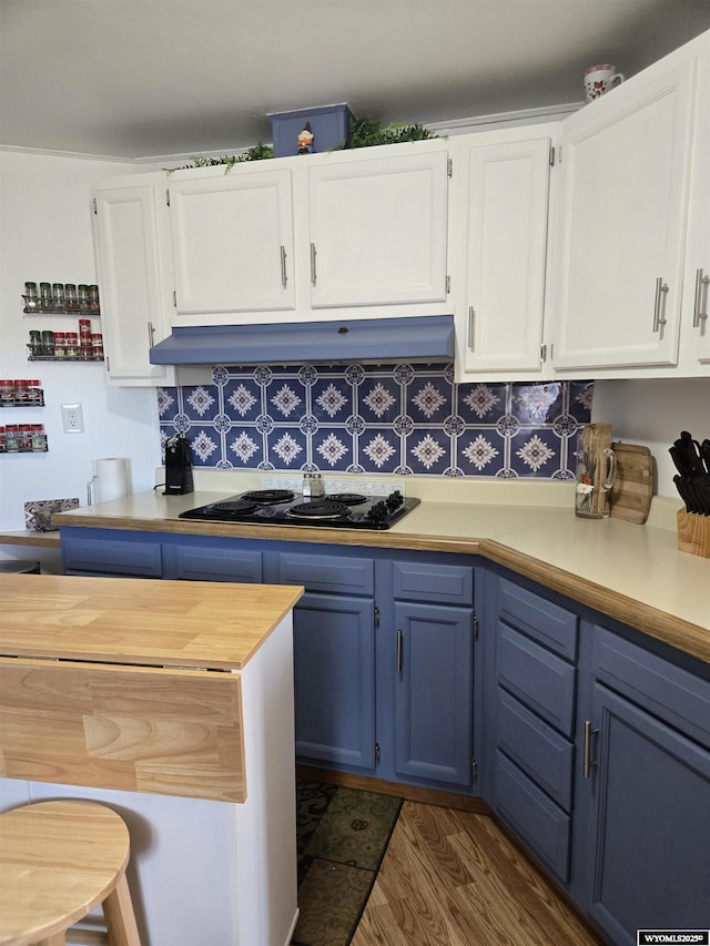 716 E 3rd St, Marbleton, WY 83113 - kitchen with blue cabinets, stovetop, under cabinet range hood, dark wood-type flooring, and white cabinetry