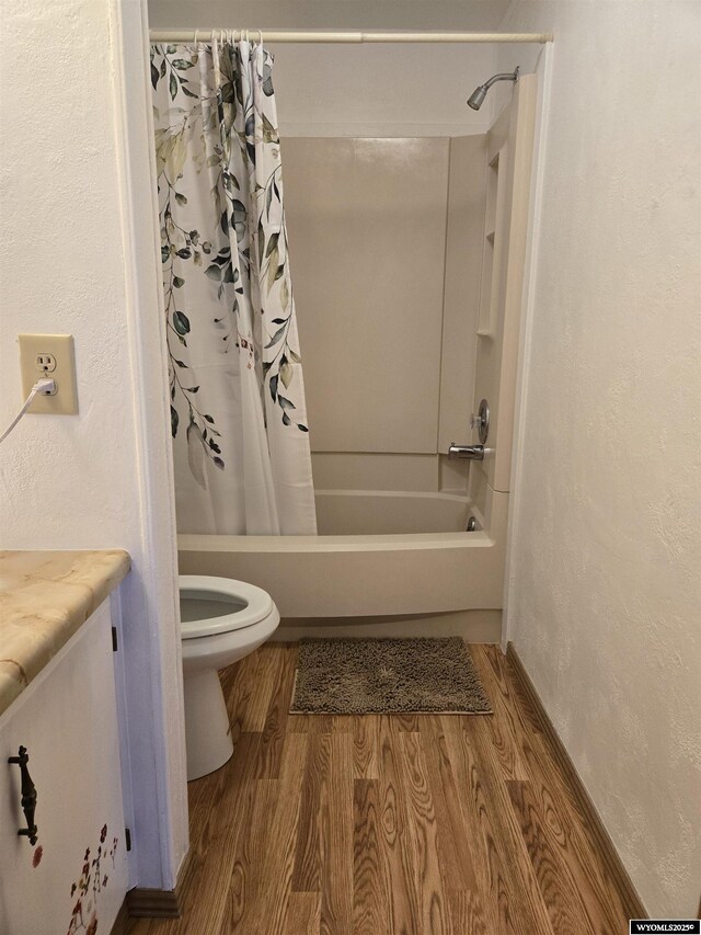 716 E 3rd St, Marbleton, WY 83113 - full bath with wood finished floors, shower / bath combo with shower curtain, a textured wall, and toilet