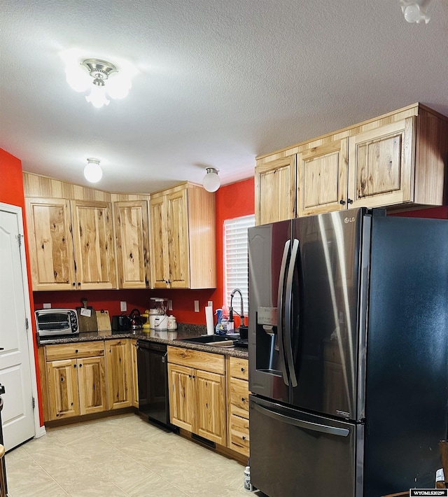 65 Eagle Ln, Lyman, WY 82937 - kitchen featuring stainless steel fridge, dishwasher, a sink, a textured ceiling, and dark stone counters