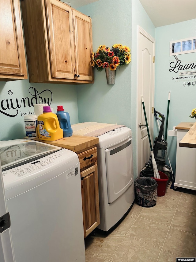65 Eagle Ln, Lyman, WY 82937 - laundry area featuring cabinet space, washing machine and dryer, and light tile patterned flooring