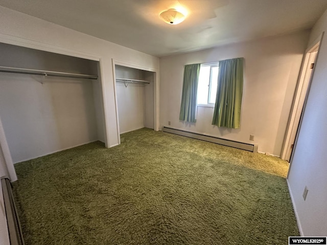 unfurnished bedroom with a baseboard heating unit, multiple closets, and carpet flooring