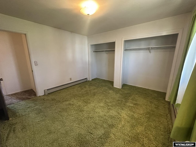 unfurnished bedroom with a baseboard heating unit, two closets, and carpet floors