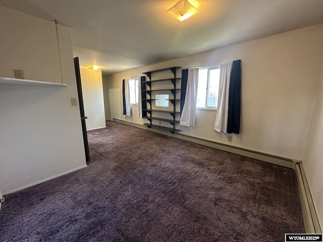 spare room with carpet floors, baseboard heating, healthy amount of natural light, and baseboards