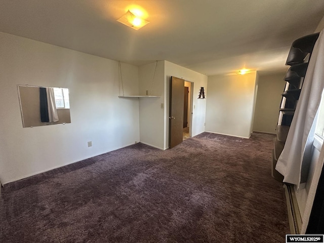 empty room with dark carpet and baseboards