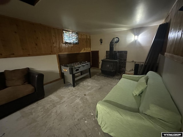 living area featuring wood walls and a wood stove