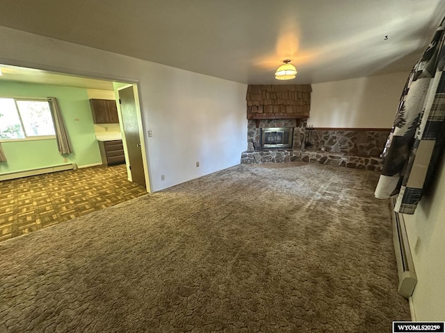 unfurnished living room featuring a fireplace, baseboard heating, and dark colored carpet
