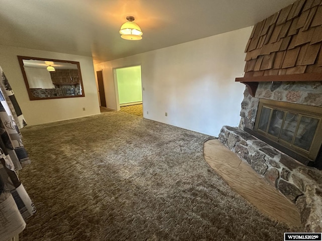 unfurnished living room featuring a fireplace, carpet, and a baseboard radiator