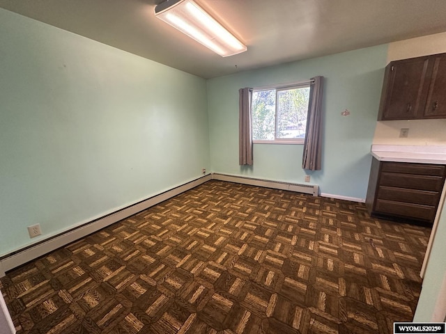 unfurnished room featuring baseboard heating and baseboards