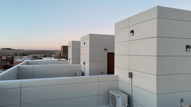 balcony at dusk featuring ac unit