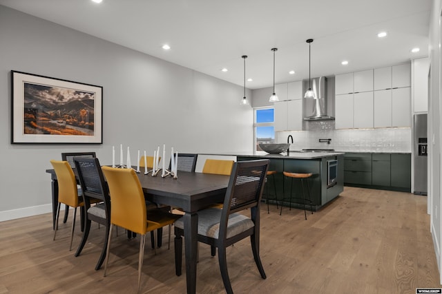 dining area featuring recessed lighting, light wood-style floors, and baseboards