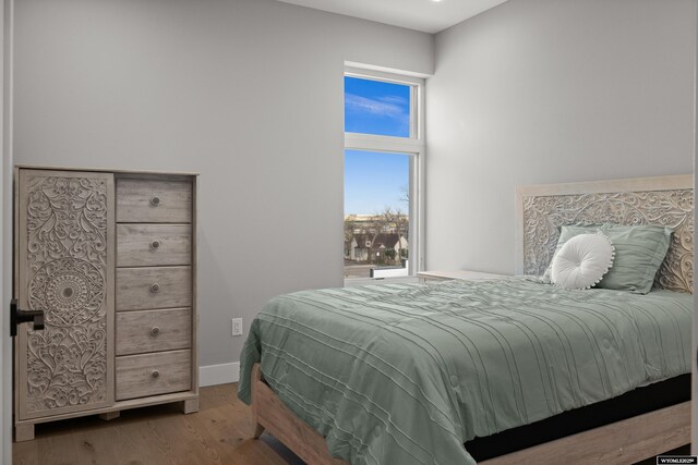 bedroom with wood finished floors and baseboards