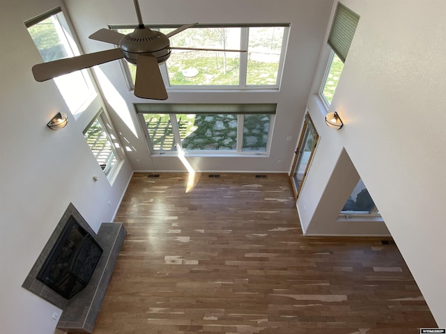 4230 S Oak St, Casper, WY 82601 - unfurnished living room with a high ceiling, a ceiling fan, plenty of natural light, wood finished floors, and baseboards