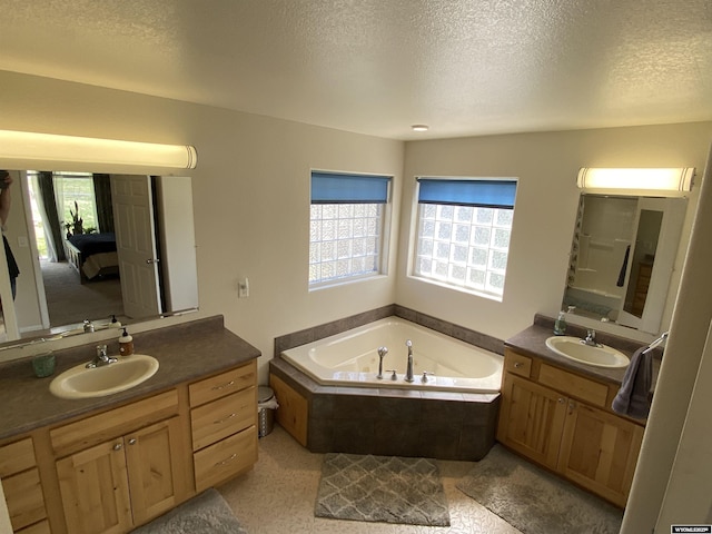 4230 S Oak St, Casper, WY 82601 - bathroom with a bath, a textured ceiling, and two vanities