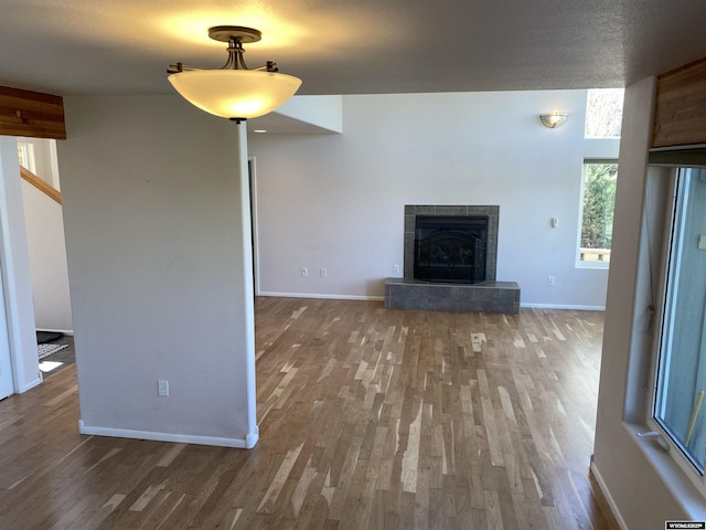 4230 S Oak St, Casper, WY 82601 - unfurnished living room featuring wood finished floors, baseboards, and a tiled fireplace