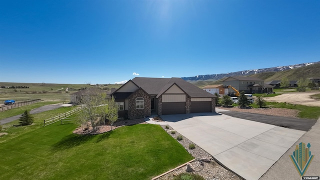 english style home featuring a garage, concrete driveway, and a mountain view