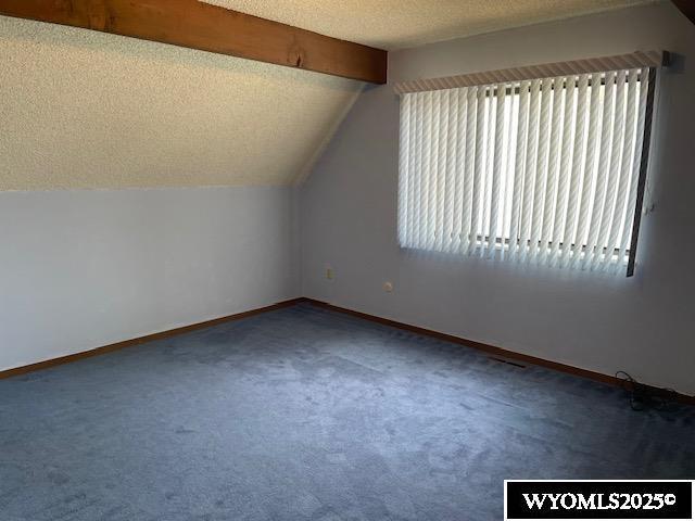 bonus room with lofted ceiling, carpet flooring, and baseboards