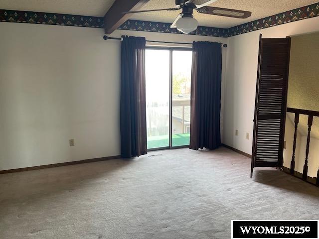 empty room featuring ceiling fan, carpet flooring, and baseboards