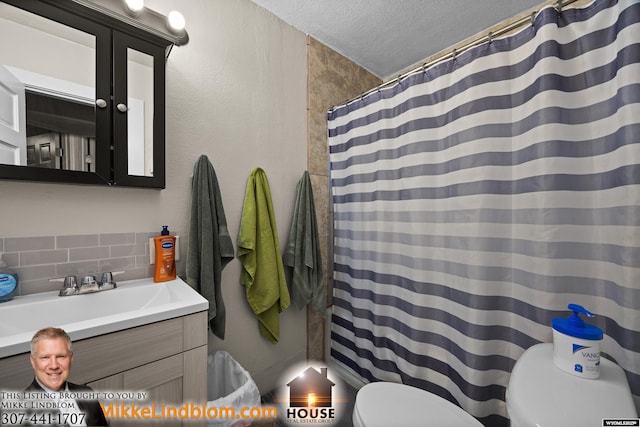 full bathroom featuring toilet, tasteful backsplash, a textured ceiling, vanity, and a textured wall