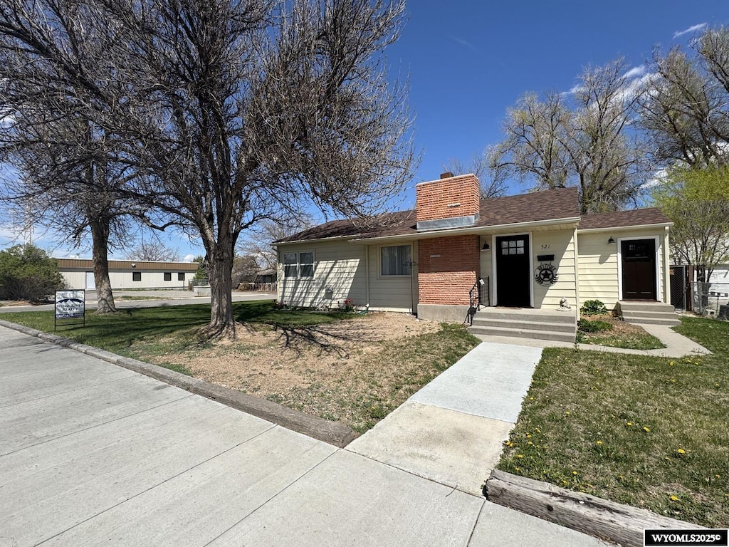 521 N 6th St E, Riverton, WY 82501 - ranch-style home with a chimney and a front yard