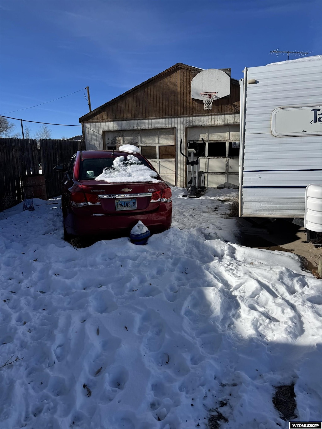 107 N Lyman St, Lyman, WY 82937 - snow covered garage featuring a garage and fence
