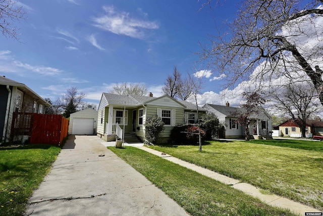 bungalow-style home with driveway, an outbuilding, and a garage